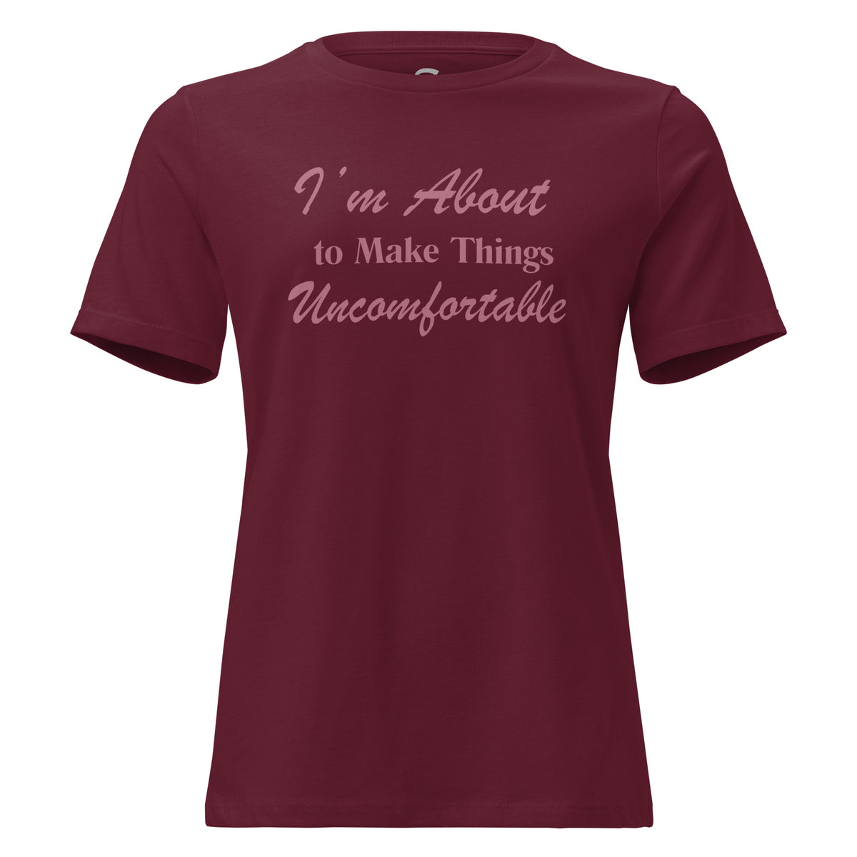 A maroon short-sleeve crewneck T-shirt with the text 'I'm About to Make Things Uncomfortable' printed in a light pink script font across the chest.